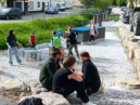 Kinder planschen am Brunnen auf dem Dorfplatz